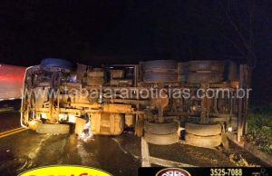 Caminhão desvia para não bater em moto mas perde o controle e tomba na BR 153 em Jacarezinho.